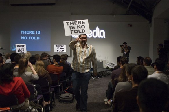 A web deisgner holding a 'there is no fold' banner